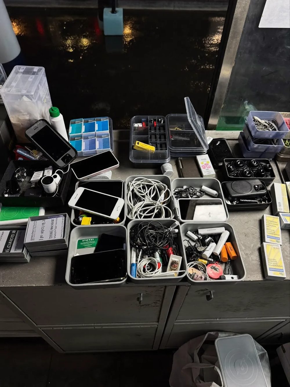 Cables, cases and spare parts crowding a shop counter.